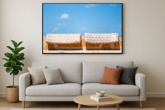 A photo of mattresses being aired out on a wall against the blue sky